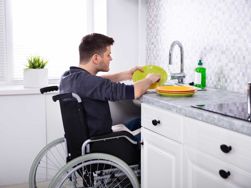 HandicappedManCleaningDishesInKitchen